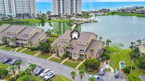 Área residencial com várias casas de dois andares, um campo de golfe e um corpo de água ao fundo.