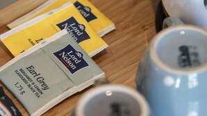 A tray with tea boxes and two grey mugs on a wooden surface. - Stagiates Guest House Room 3 (Volos)