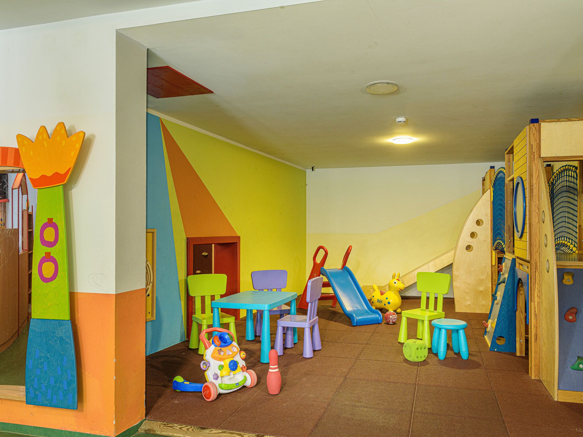 A children's play area with colorful furniture and a slide.