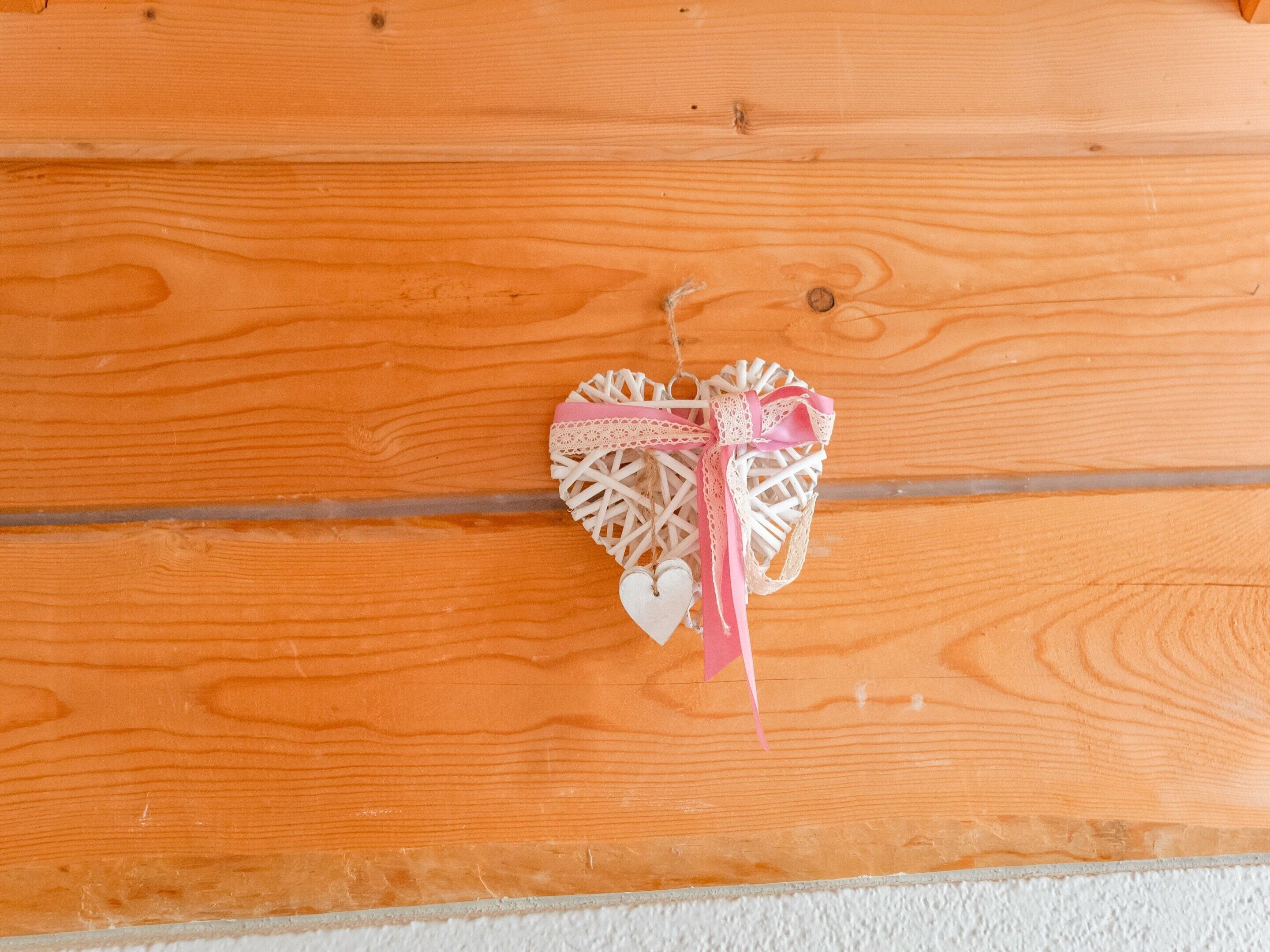 A wooden wall with a decorative heart-shaped ornament.