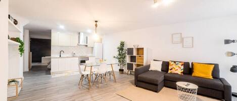 Un appartement moderne comprenant une cuisine, un coin repas et un salon.