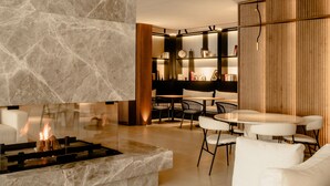 A modern living room with a marble fireplace, white sofas, and a wooden bookshelf. - THE FLAG Hotel Marbella Estepona - Adults Recommended (Estepona)