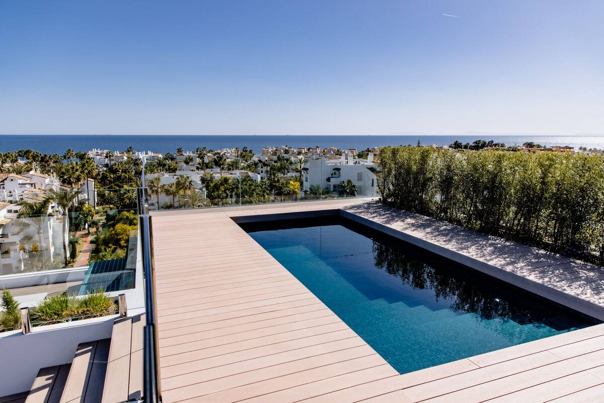A rooftop pool with a clear view of the sea and surrounding buildings.