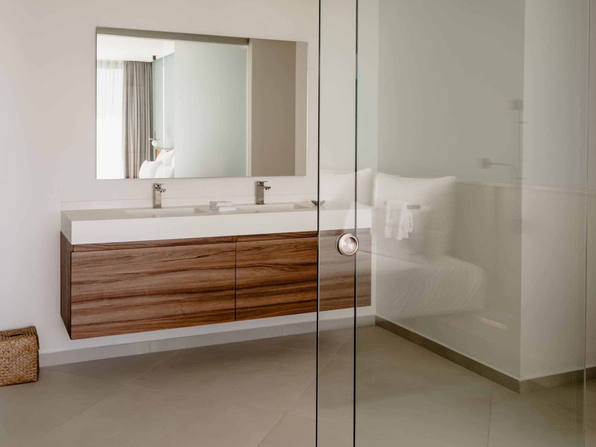 Une salle de bain moderne avec une douche à parois de verre, un meuble-lavabo en bois et un grand miroir.