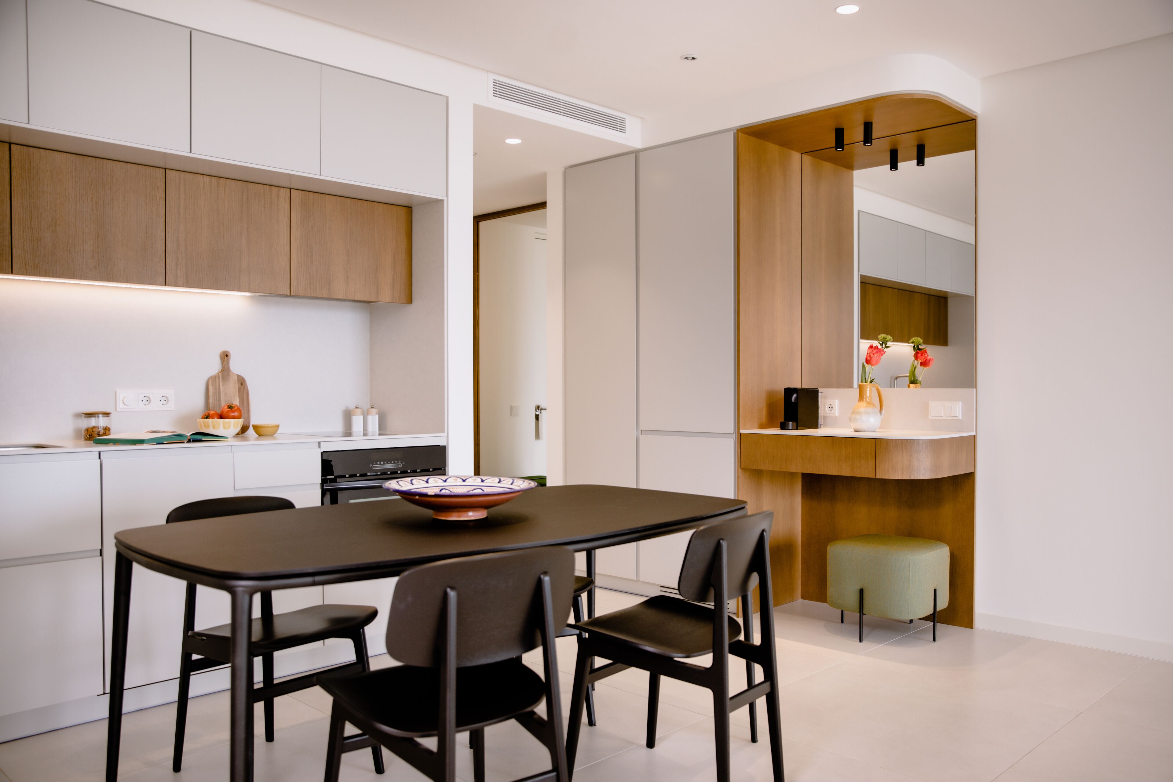Una cocina moderna con zona de comedor, que presenta un gran comedor, sillas y un armario de madera.