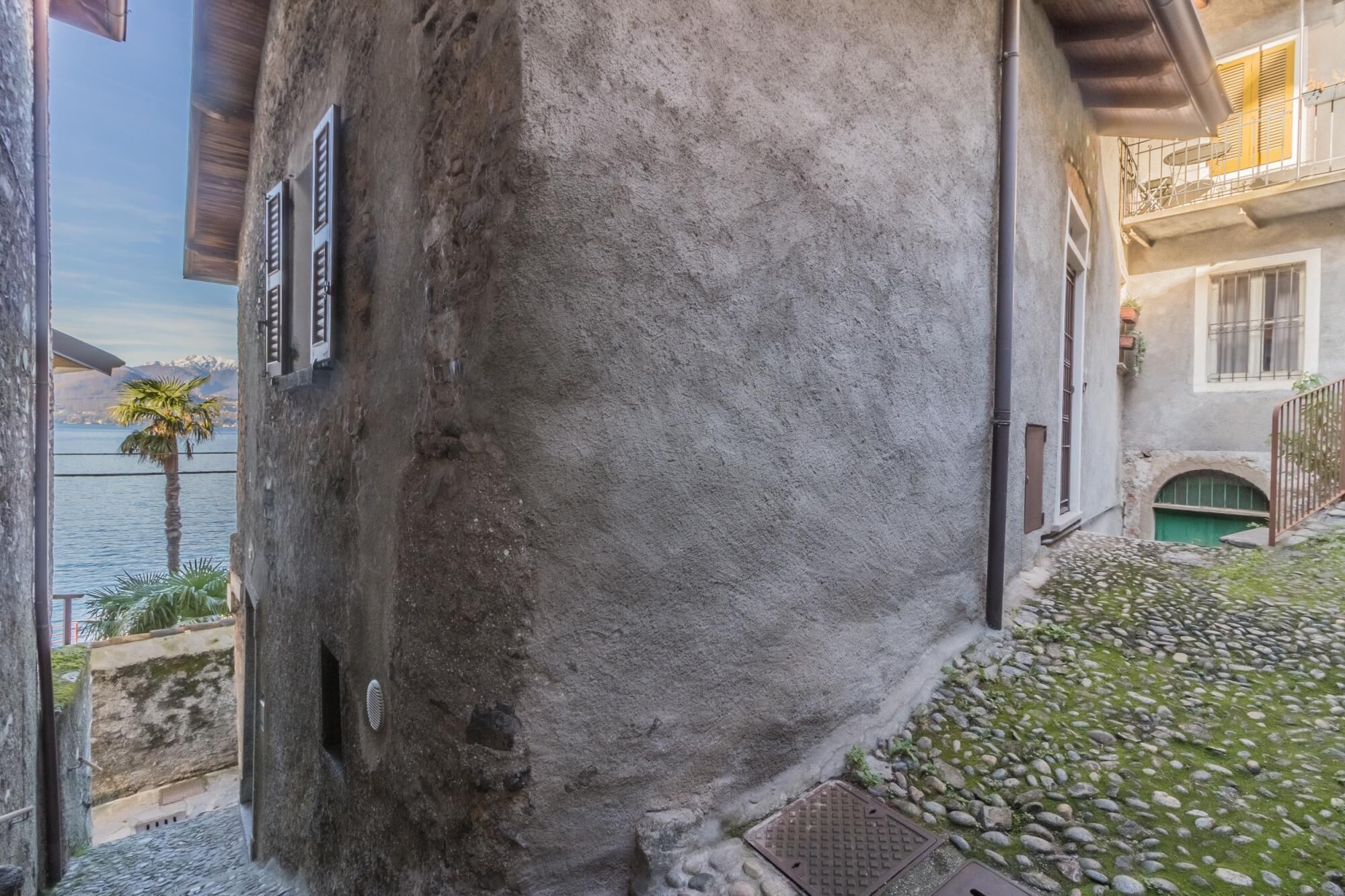 Un bâtiment en pierre doté d’un balcon donnant sur une étendue d’eau.