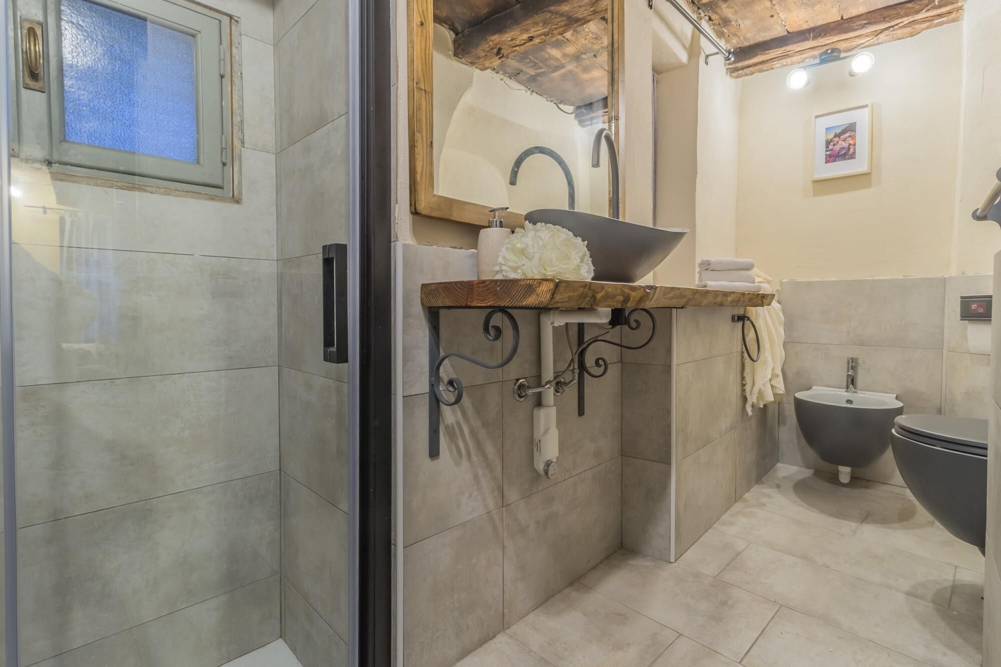A bathroom with a large sink, a mirror, and a bidet.