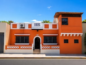 A two-story building with a sign reading 'HB HOTEL BELLA LUZ' and the number '1010' above the entrance.