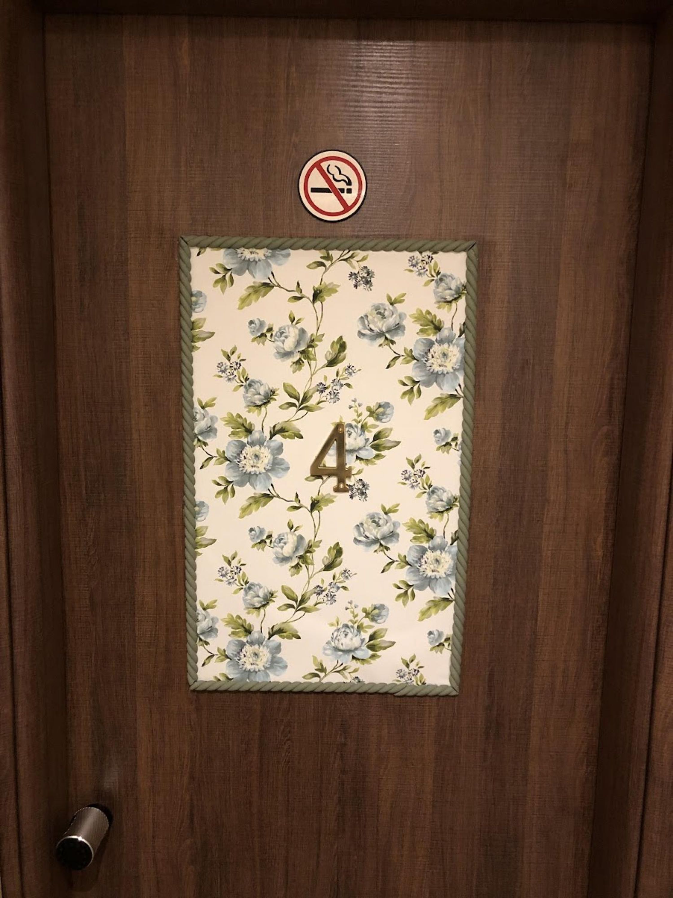 A wooden door with a floral pattern and the number 4.