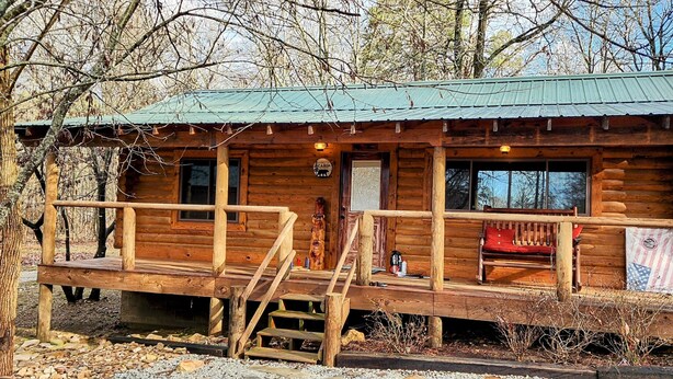 A rustic log cabin with a porch, wooden steps, and a bench. - Music Mountain Retreat Cabin B (Hot Springs)
