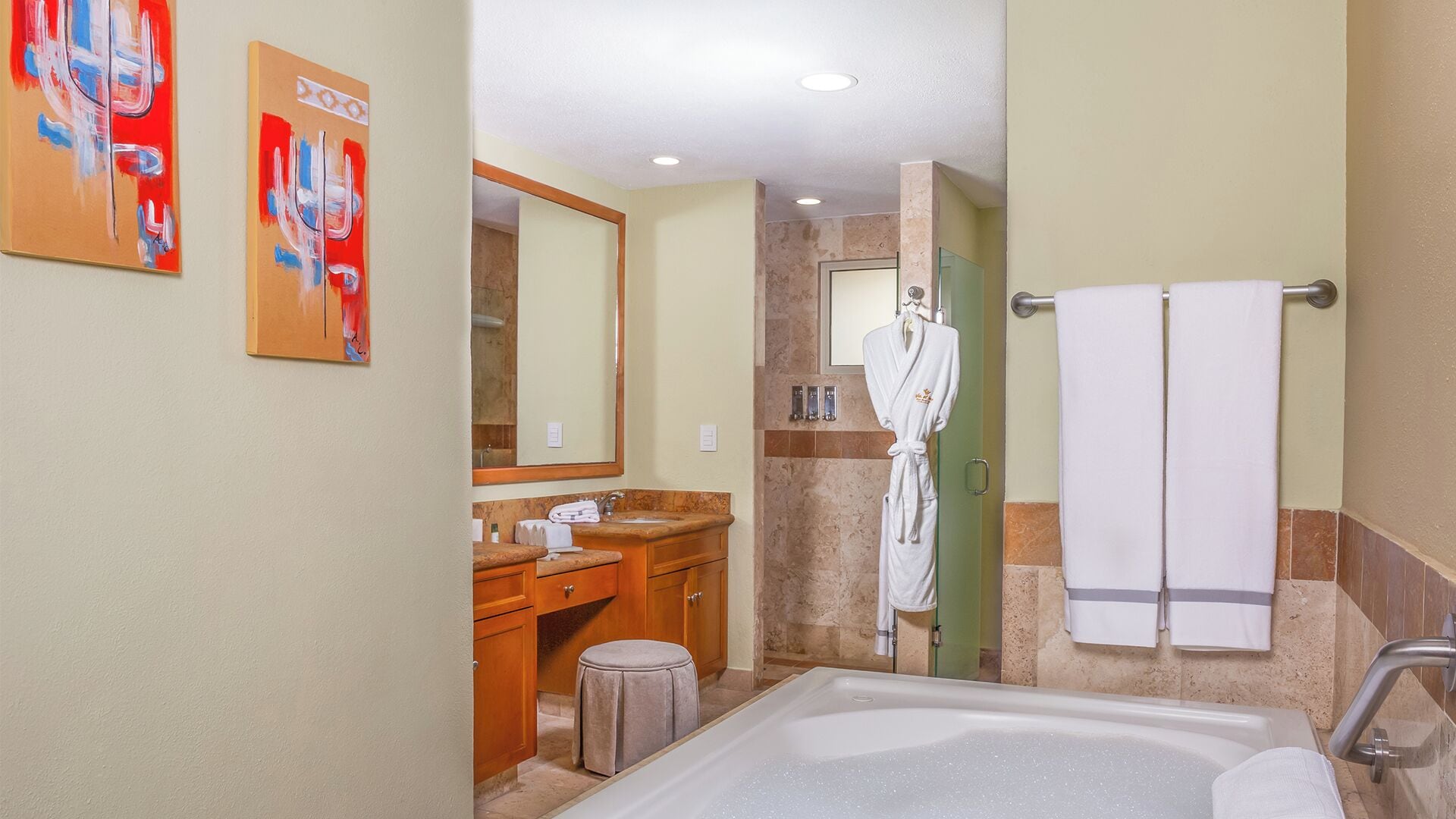 A modern bathroom with a bathtub, vanity, and a robe hanging on a towel rack.