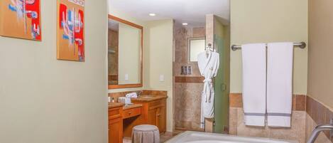 A modern bathroom with a bathtub, vanity, and a robe hanging on a towel rack.