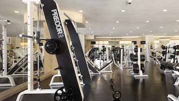 Un gimnasio con diversos equipos de ejercicio, incluyendo máquinas de pesas y pesas libres.