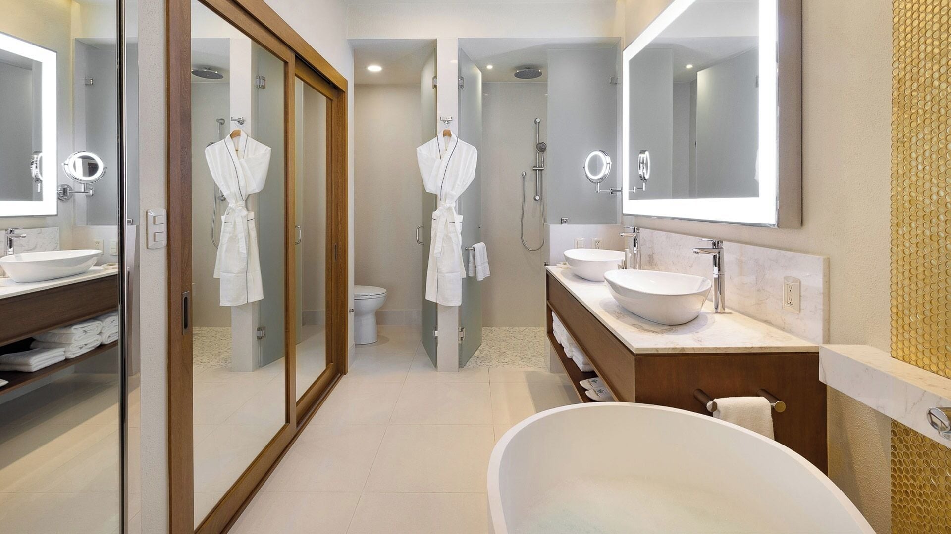 A modern bathroom with a freestanding bathtub, two sinks, and a large mirror.