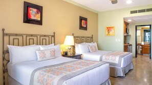 A hotel room with two beds, a nightstand with a lamp, and artwork on the walls. - Villa del Arco Beach Resort & Spa Cabo San Lucas - All Inclusive (Cabo San Lucas)