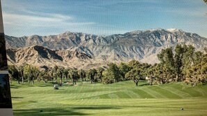 Un parcours de golf avec une chaîne de montagnes en arrière-plan.