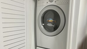 A front view of a laundry room with two stacked front-loading washing machines.