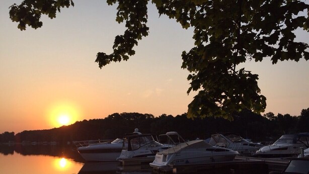 Un puerto deportivo con barcos amarrados al atardecer.