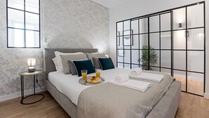 Un dormitorio moderno con cama, mesita de noche y vistas a través de un panel de vidrio.