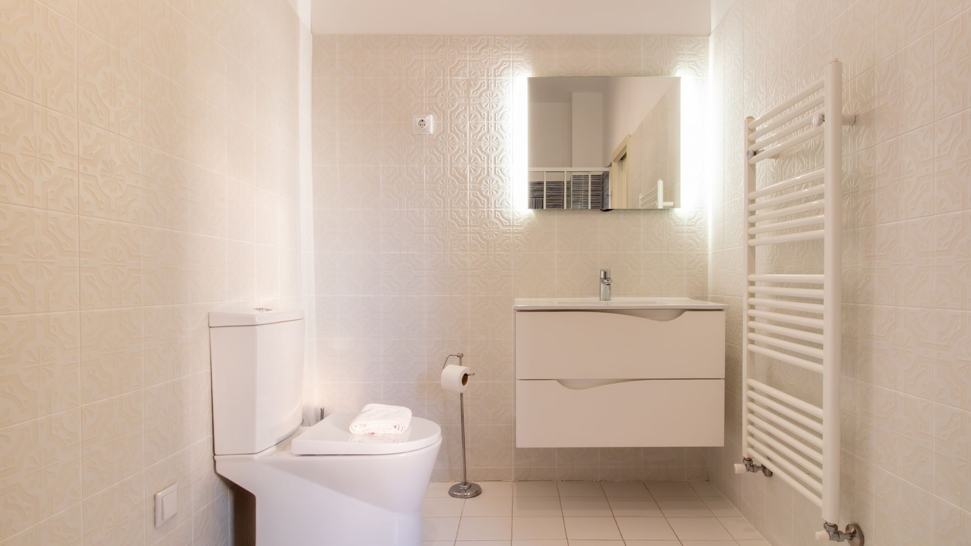 Un bagno piccolo e pulito con il water, un lavandino e un portasciugamani.