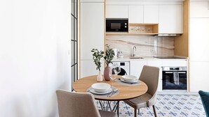 A modern kitchen with white cabinets, a Bosch microwave, and a sink. - Urban House - D - by LovelyStay (Porto)