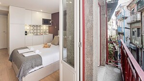 Una habitación de hotel con una cama, una kitchenette pequeña y vista a la calle.