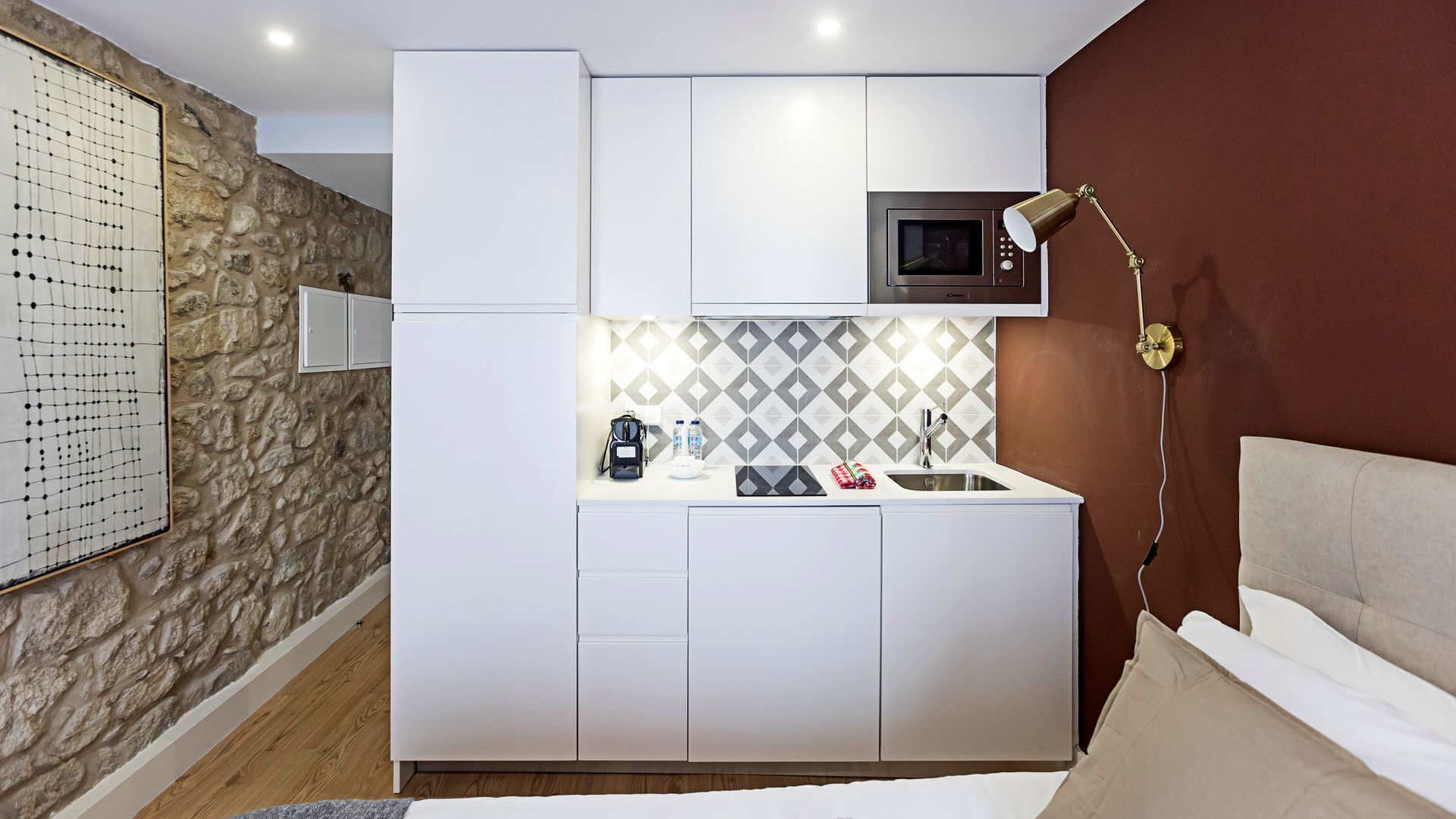 Una kitchenette compacta con microondas, un lavamanos y una encimera.