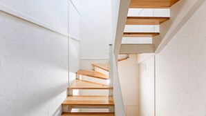 Una escalera moderna con escalones de madera y paredes blancas.