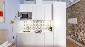 Cozinha compacta com micro-ondas, pia e bancada.