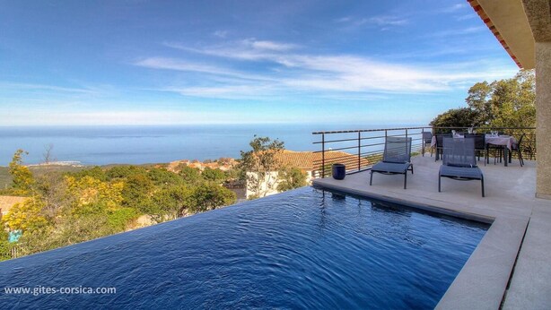 A swimming pool with a view of the sea and a patio area with chairs and tables. - Bergerie, Panoramic sea view, Heated pool, Gr20 access (Sari-Solenzara)