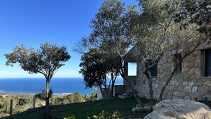 A stone building with a stone window and a view of the sea. - Bergerie, Panoramic sea view, Heated pool, Gr20 access (Sari-Solenzara)