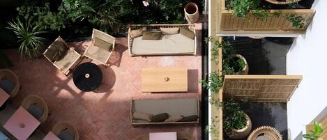 An outdoor seating area with wicker furniture and potted plants.