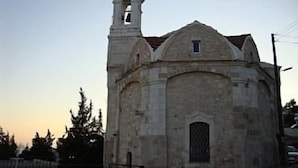 Una iglesia con un campanario y una ventana pequeña.