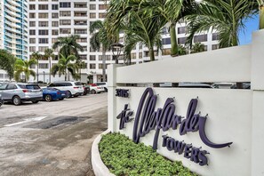 A parking lot with cars and a sign for The Colony Towers. - Stylish Beachfront Gem ~ Sea View, Pool, Gym, Pkg! (Hollywood)