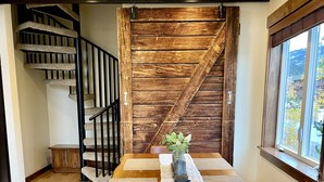 A dining area with a wooden table, benches, and a staircase. - Newly Updated, Cozy and Spacious Condo! (Frisco)