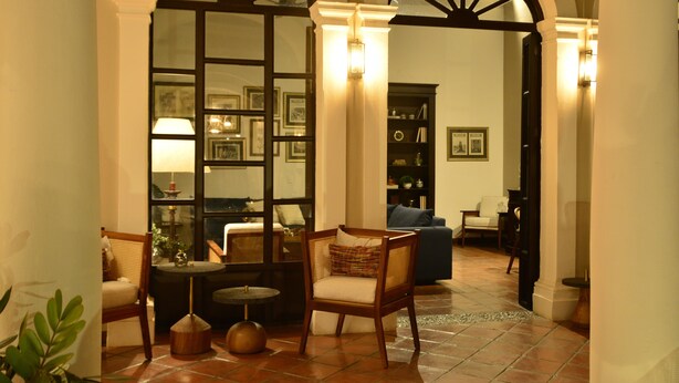 Un vestíbulo acogedor con una silla de madera, una mesita y una estantería.