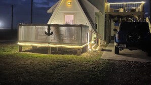 A two-story house with a porch, a garage, and a vehicle parked in front.