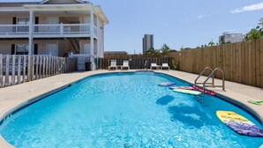 A swimming pool with lounge chairs and a wooden fence. - Two 2BD/2BA 1st floor Condos for Group/Family/Sports Team Vacation (Gulf Shores)