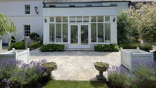 A traditional house with a conservatory, stone pathway, and lavender plants. - Stunning and Luxurious Manor House Holiday Home (Dorchester)