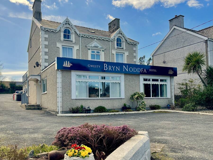 Un hôtel à deux étages, de style architectural classique, qui se distingue par une enseigne bien visible portant le nom « Bryn Noddfa Hotel ».