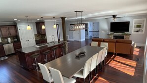 A modern kitchen with a central island, bar stools, and pendant lighting. - The Chalet on Lake Wylie, 5000 sq ft, Sleeps16, Pet Friendly, Close to Charlotte (Belmont)