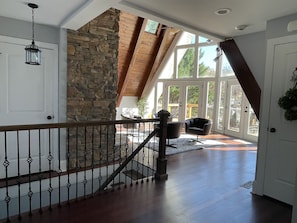 Sitting room with A-frame windows and stairs to the basement level 