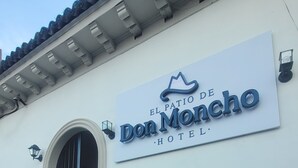 A hotel sign for "El Patio de Don Noncho Hotel" with a decorative crest above the name. - Hotel El Patio de Don Moncho (Santa Tecla)