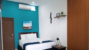 A hotel room with a bed, a bedside table, a wall-mounted shelf with a plant, and an air conditioning unit. - Hotel El Patio de Don Moncho (Santa Tecla)