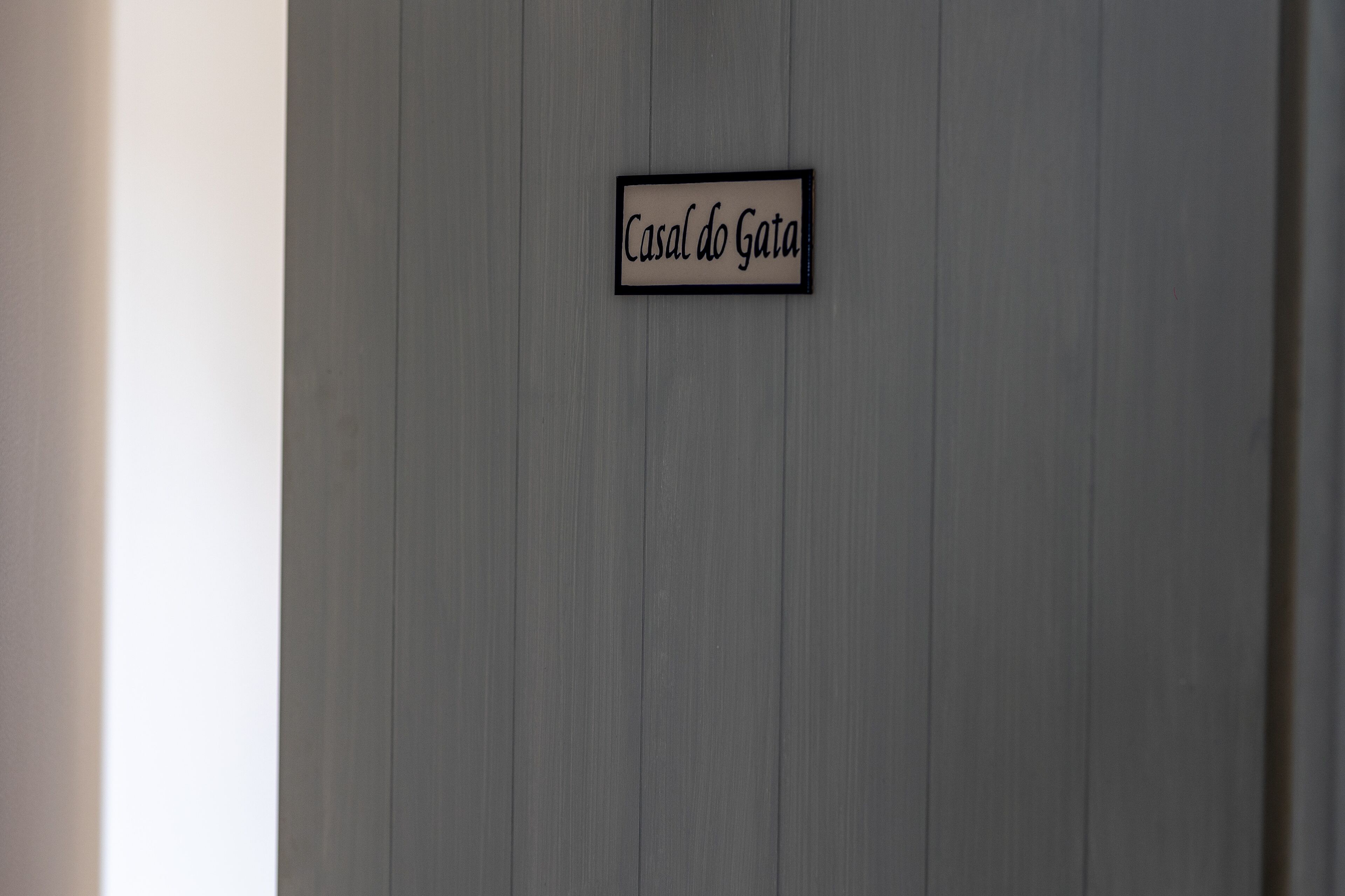 Un letrero con el texto 'Casal do Gata' en una pared.