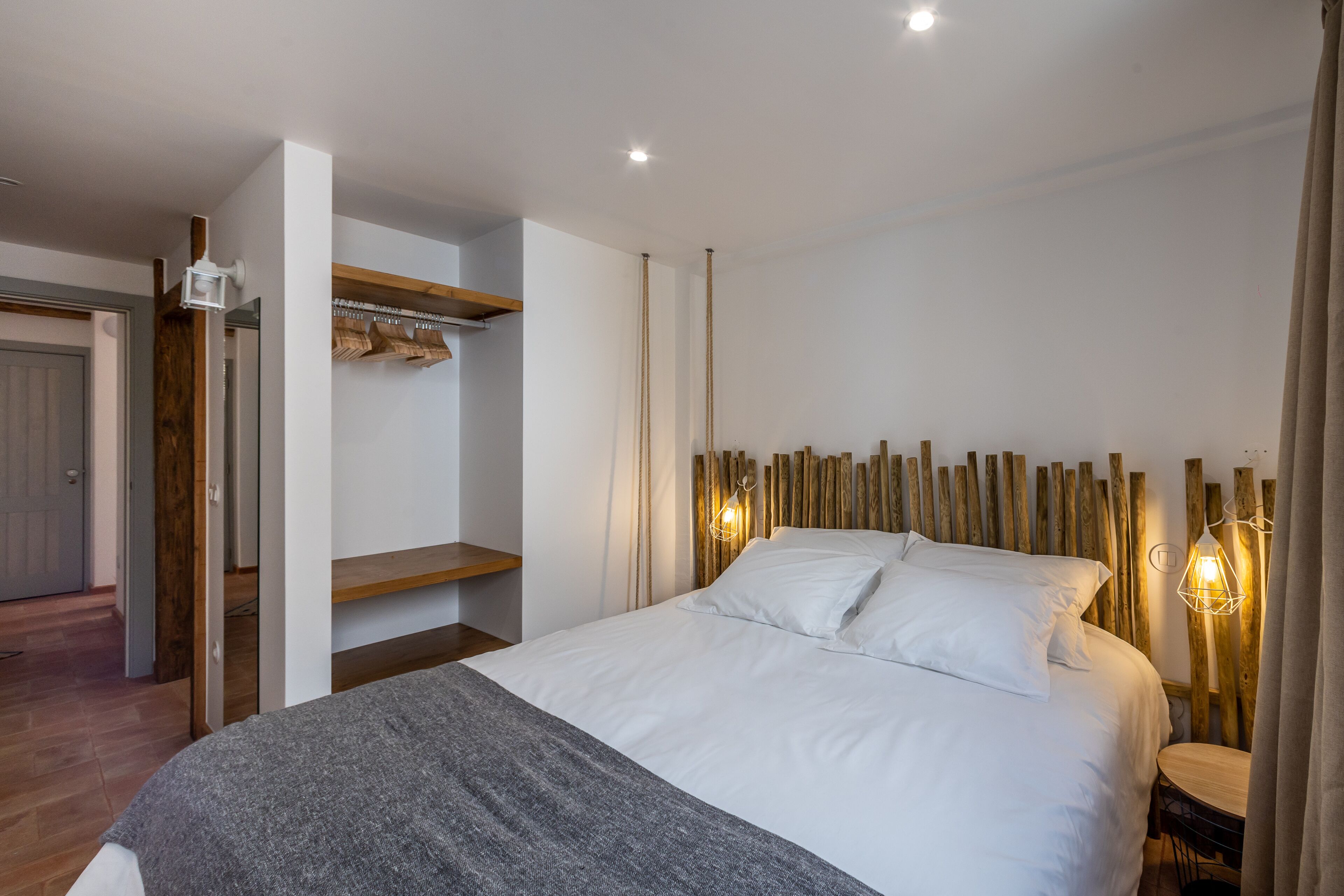 A bedroom with a bed, bedside table, and a wooden headboard.