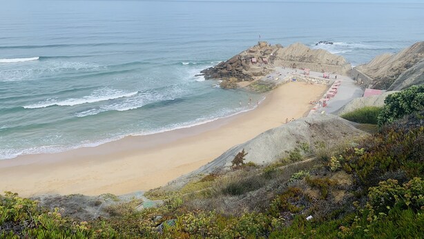 A coastal beach with a rocky outcrop, a sandy shore, and a clear view of the ocean. - Villa Galega (Torres Vedras)