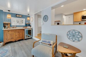 A kitchen with wooden cabinets, a built-in oven, and a dining area with a chair and table.