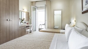 A hotel room with a large bed, a desk with a chair, a mirror, and a bathroom visible through an open door. - Hotel Baltic (Rimini)