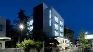 A modern hotel with a prominent 'HOTEL BALTIC' sign, a gated entrance, and a parking area with a no parking sign. - Hotel Baltic (Rimini)